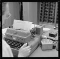 An unidentified faculty member working with a teletypewriter