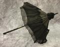 Parasol of black silk trimmed at the top and bottom with overlay of fine silk chiffon