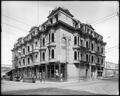 Esmond Hotel at corner of Front and Morrison, Portland. Building materials on street in foreground, construction in street level shops.