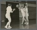 Three women playing basketball in gym class, 1938