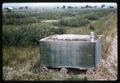 Large wooden box in middle of field, circa 1966