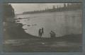 Man displaying dead bird, river in background, circa 1910