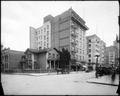 House on corner of N. E. Park and Alder, Portland, surrounded by commercial buildings. On site of Woodard Clark & Co. Horse-drawn wagon on corner, Cornelius Hotel in background.