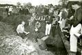 Art King, standing in ditch and wearing light colored jacket, addressing a group of students, circa 1950