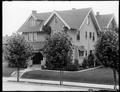 Front on William McMurray house on Clackamas St., Portland. Row of trees in foreground.