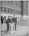 An unidentified individual and President August Strand in front of Commerce Hall on commencement day, June 1959