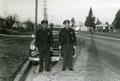 Portland policemen standing in front of their patrol car