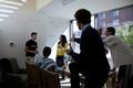 Students writing on white board wall in Global Scholars Hall