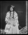 Umatilla Indian woman in beaded dress, with decorated bag