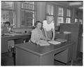 Mrs. Lavina Lynch Hunt, normally an English teacher at Washington High School, is guided by Mrs. Iva Clark through the labyrinth of Pacific Telephone and Telegraph's payroll department, August 10, 1950