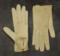 Gloves of white kidskin with single metal button closure at wrists