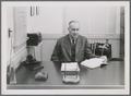 Ernest H. Wiegand sitting at desk, circa 1940