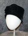 Bucket hat of black ribbed velvet (silk velvet faille) with small dropped brim and large floral design of self-velvet at center-front