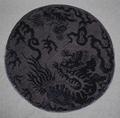 Roundel of black cut and uncut silk velvet in a design of stylized tigers and clouds