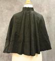 Cape of black silk twill accented with bead design and braided cord