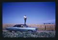 Bob Henderson taking pictures from top of car adjacent to a wheat field, Oregon, May 23, 1975