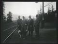 Group of men by railroad tracks