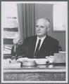 James H. Jensen seated at desk, circa 1965