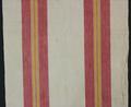 Towel of natural hand-woven cotton with two vertical bands of varying stripes in red, yellow, and white
