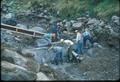 Men with concrete in rocky streambed