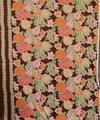 Textile yardage of brown polyester with pattern of varied, overlapping flowers in pink, orange, taupe, white, and pale green