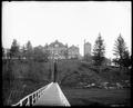 Buildings of Oregon State Training School, Salem, in distance, on far side of ravine. Wooden walk and stairway leading from foreground to school.
