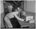 R. W. Peterson, graduate assistant, and Milosh Popovich, staff member, around equipment that tested engine wear in automobiles with radioactive pistons, 1953