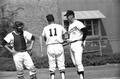 Coach Gene Tanselli confers with pitcher and catcher