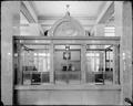 Interior detail, two tellers' cages in US National Bank, Portland. Bars and glass windows on counter, wall clock above windows.