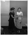 One woman applying alterations to another woman's dress