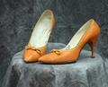 Pumps of orange leather trimmed around the opening with a yellow thin leather band