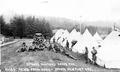 Soldiers near tent camp reading mail