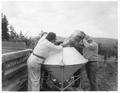Men pouring seed into hopper
