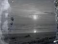 Man walking on beach (Pacific Ocean?) at sunset