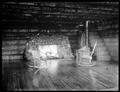 Fireplace in log cabin, Story, OR. Two rocking chairs in front of fire, stairway of log rounds in corner.