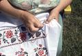 Pictures of Mrs. Shalduha embroidering, showing how the sleeve will look on her arm.