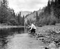 E. D. Cox fishing in the Umatilla River at Buck Creek Organization Camp, Umatilla National Forest