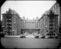 Full front view of Portland Hotel, with autos and taxi cab on 6th St. in foreground.