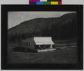 Rondowa Hotel and post office at Rondowa, OR. Isolated building with people on awning-covered porch. Hillside in background. (recto)