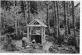 Two men and construction materials working on partially finished structure (Registry Booth)