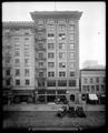 Conch Building on 4th St., Portland. Music store at street level. Three autos parked on street in foreground.