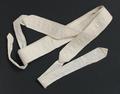 Belt of white woven cotton in a textured pattern of floral shapes on a diamond diaper ground
