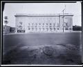 Front view, Portland Civic Auditorium. US Food Administration billboard on building, manhole cover in 3rd St. in foreground.