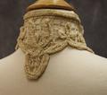 High standing band collar of cream colored crocheted net with embroidered chenille yarn in floral design