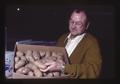Paul Barnes of Madras Produce Company with box of potatoes, Madras, Oregon, 1976