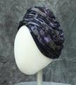 Turban of purples, blue, and green jersey knit in a camouflage pattern