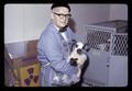 Paul Weswig holding lamb in plastic bag, Oregon State University, Corvallis, Oregon, circa 1970