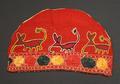 Part of a cap of red cotton embroidered in colorful silks with medallions along the bottom