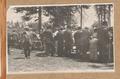 Group of people standing around tables Image entitled ""Friend Picnic, 1918""
