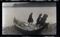Unidentified children beside a canoe